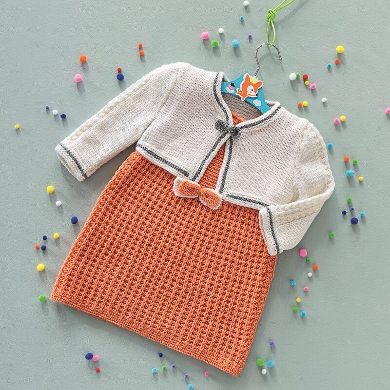 Gestricktes Babykleid mit cremefarbenem Bolero und strukturiertem orangefarbenem Kleid