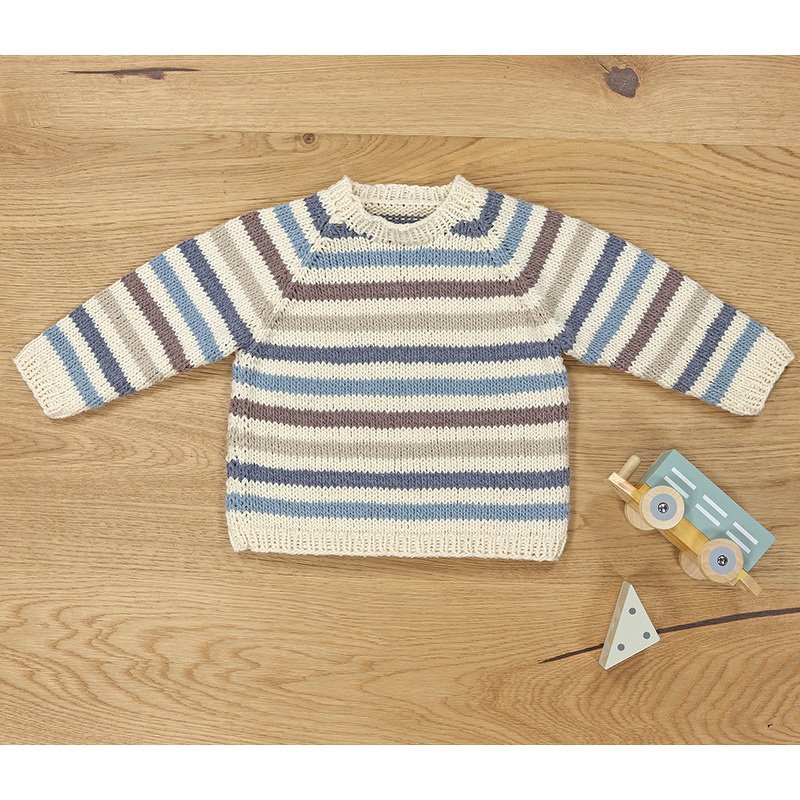 Gestrickter Kinderpullover in Creme mit blauen, grauen und braunen Streifen, flach auf Holzuntergrund