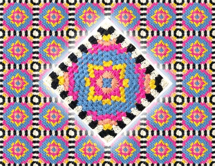 Gehäkelte Decke aus bunten Granny-Squares mit schwarz-weißem Streifenrand