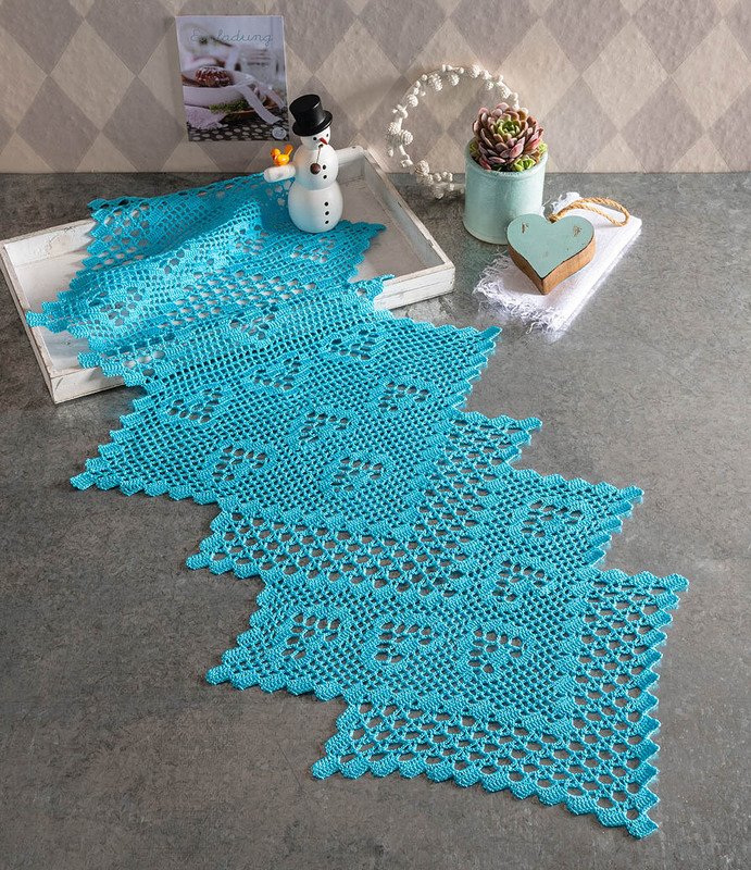 Rechteckiger Häkel-Läufer aus verbundenen quadratischen Motiven in Türkis mit gezacktem Rand auf grauer Fläche