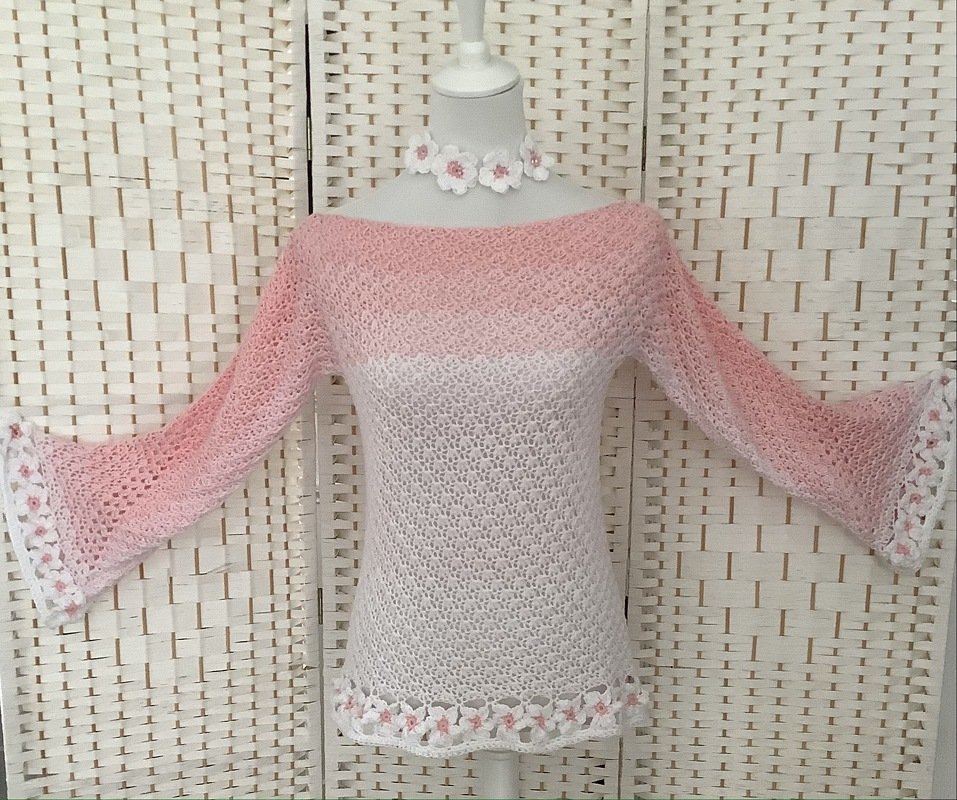 Gehäkelter rosa-weißer Damenpullover mit Ajourmuster, Glockenärmeln und Blumenbordüre auf Schaufensterpuppe