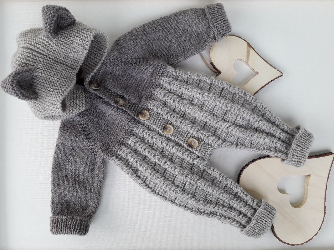 Grau gestrickter Baby-Overall mit Kapuze und Öhrchen, liegend