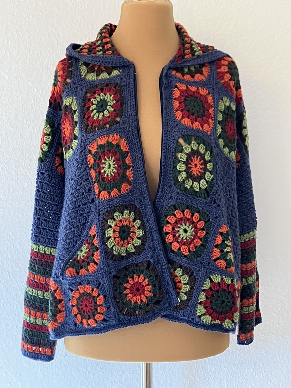 Damen-Häkeljacke aus bunten Granny-Squares mit Kapuze auf Schneiderpuppe
