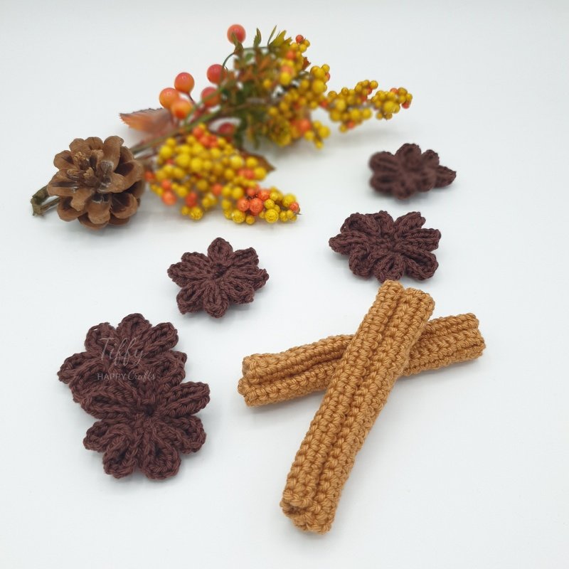 Brown crochet flower motifs and two camel rectangular strips with a pinecone and autumn berries on a white background.