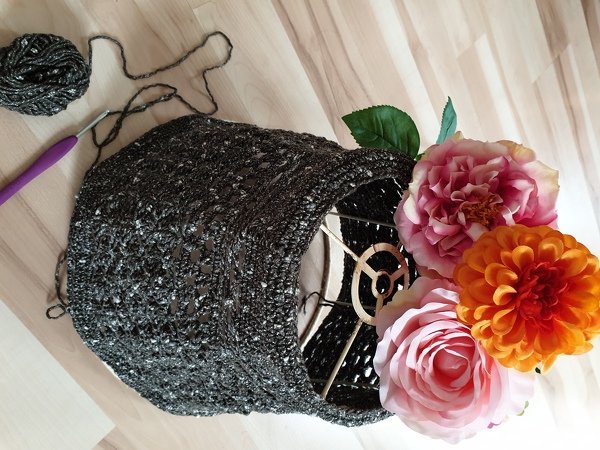 Work-in-progress crochet lampshade cover with crochet hook and yarn ball