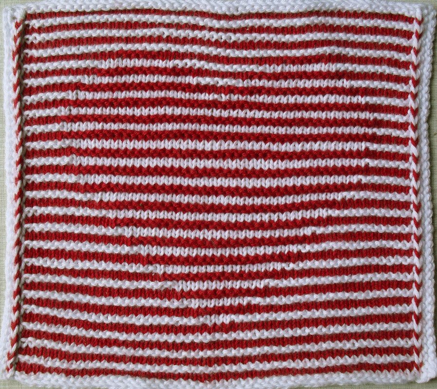 Quadratisches Strickmuster mit schmalen roten und weißen Streifen und weißem Rand