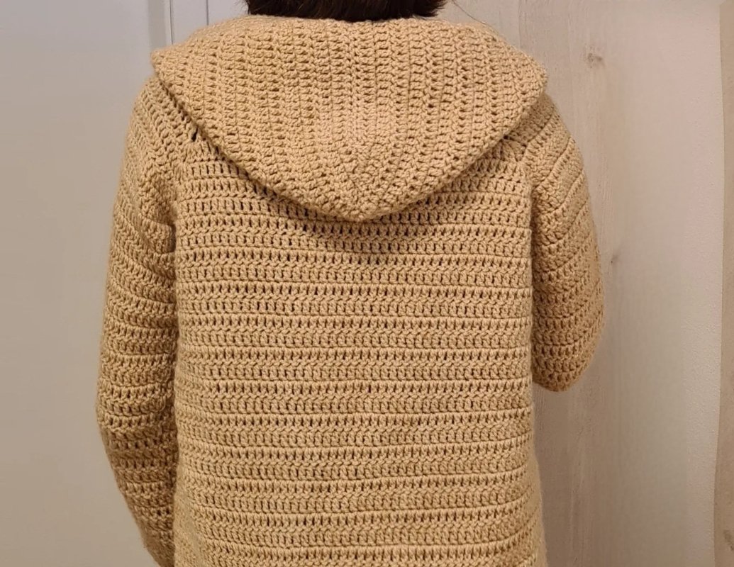 Rückenansicht einer beige gehäkelten Damenjacke mit Kapuze