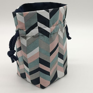 Stoffbeutel mit Chevron‑Muster (Schwarz, Weiß, Grau, Rosa) und dunkelblauem Kordelzug