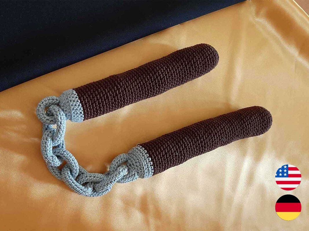 Soft brown crocheted handles joined by a gray crocheted chain on gold fabric