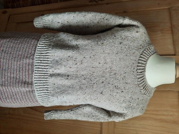 Beiger Strickpullover mit dezenten Sprenkeln und Rippenbündchen auf Schaufensterpuppe