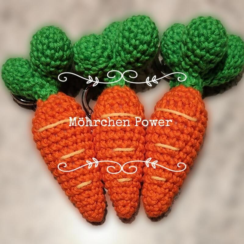 Drei gehäkelte Möhren-Schlüsselanhänger in Orange mit grünen Blättern