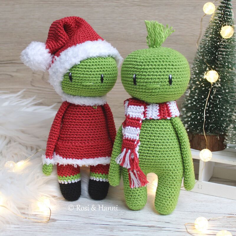 Zwei gehäkelte grüne Amigurumi, links mit rotem Nikolauskostüm, rechts mit rot-weiß gestreiftem Schal und Haarschopf