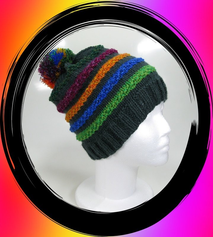 Unisex Strickbeanie mit Rippbündchen, bunten Streifen und Bommel auf weißem Schaufensterkopf