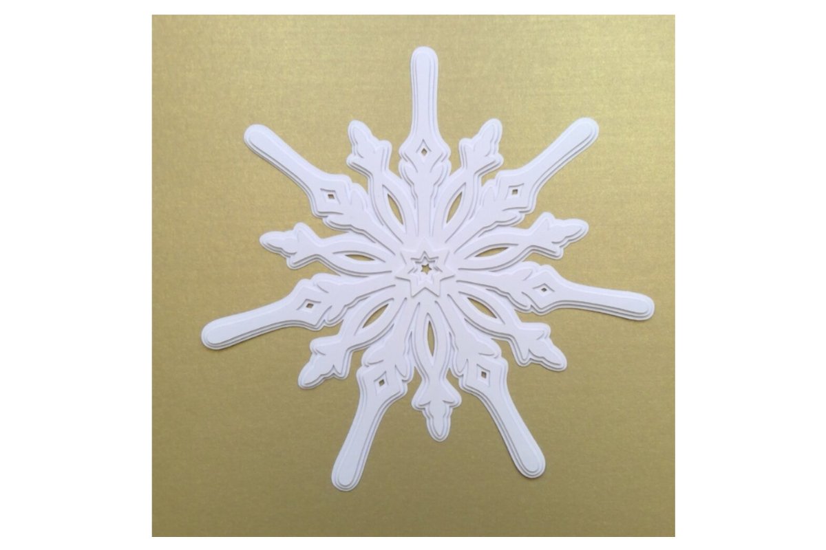 Weiße ornamentale Schneeflocke mit filigranen Aussparungen auf goldfarbenem Hintergrund