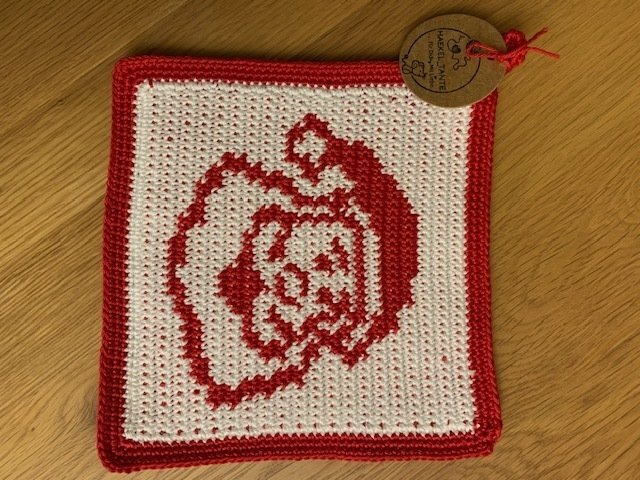 Gehäkelter Topflappen mit roter Rose auf weißem Hintergrund und rotem Rand