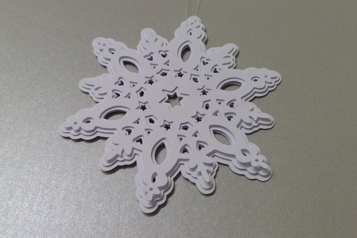 Weiß geschichtete 3D-Schneeflocke aus Papier mit filigranen Ausschnitten