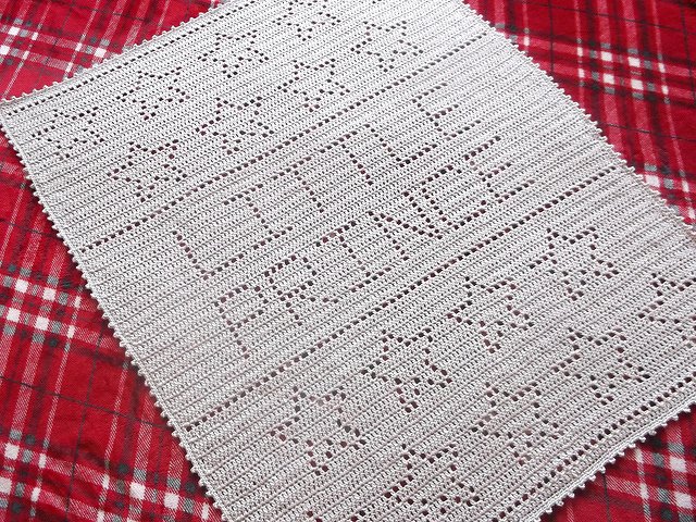 White crocheted rectangular baby blanket with filet-lettering reading "LITTLE PRINCE" and star motifs
