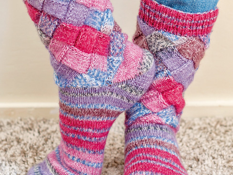 Gestrickte Flechtmustersocken in Beere-Mix