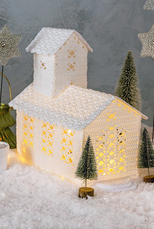 Gehäkelte weiße Kirche mit Innenbeleuchtung und Schneedekor