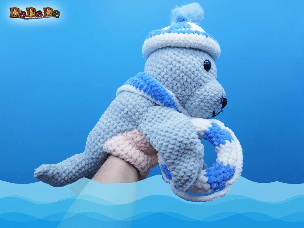 Maritime gehäkelte Robben-Handpuppe in Hellblau und Weiß mit Mütze und Rettungsring
