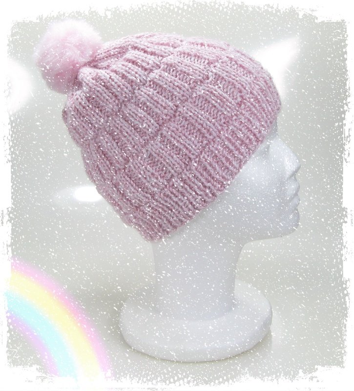Rosa Strickmütze mit Bommel und Glitzergarn auf weißem Styroporkopf, Seitenansicht