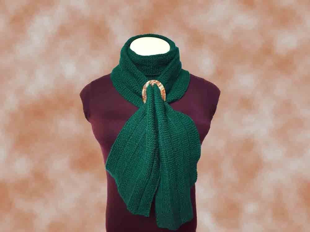 Gestrickter grüner Schal mit rundem Holzring auf einer Schaufensterpuppe