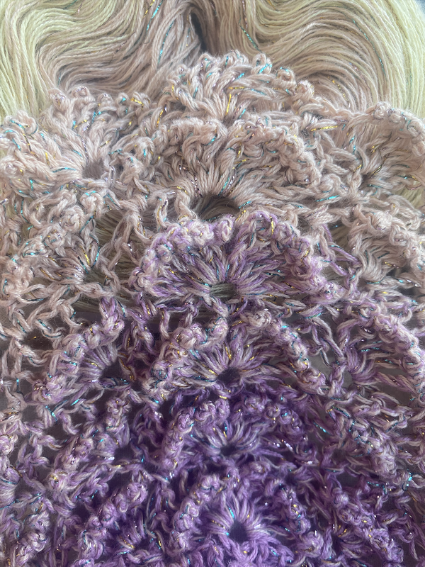 Detail gehäkeltes Dreieckstuch mit Blumen-Spitzenmuster, Verlaufsgarn von Creme zu Violett und metallisch schimmernden Fäden