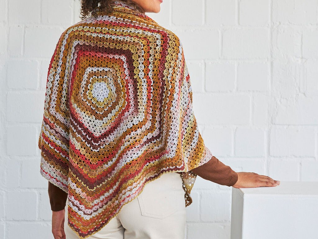 Rückansicht: gehäkeltes Poncho-Tuch mit mehrfarbigem Quadratmuster in herbstlichen Farben