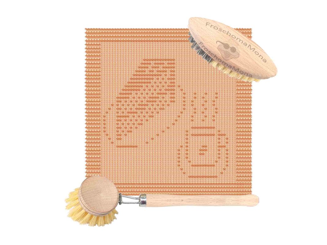 Gestricktes orange Geschirrtuch mit Frosch- und Behältermotiv, daneben zwei Holzbürsten
