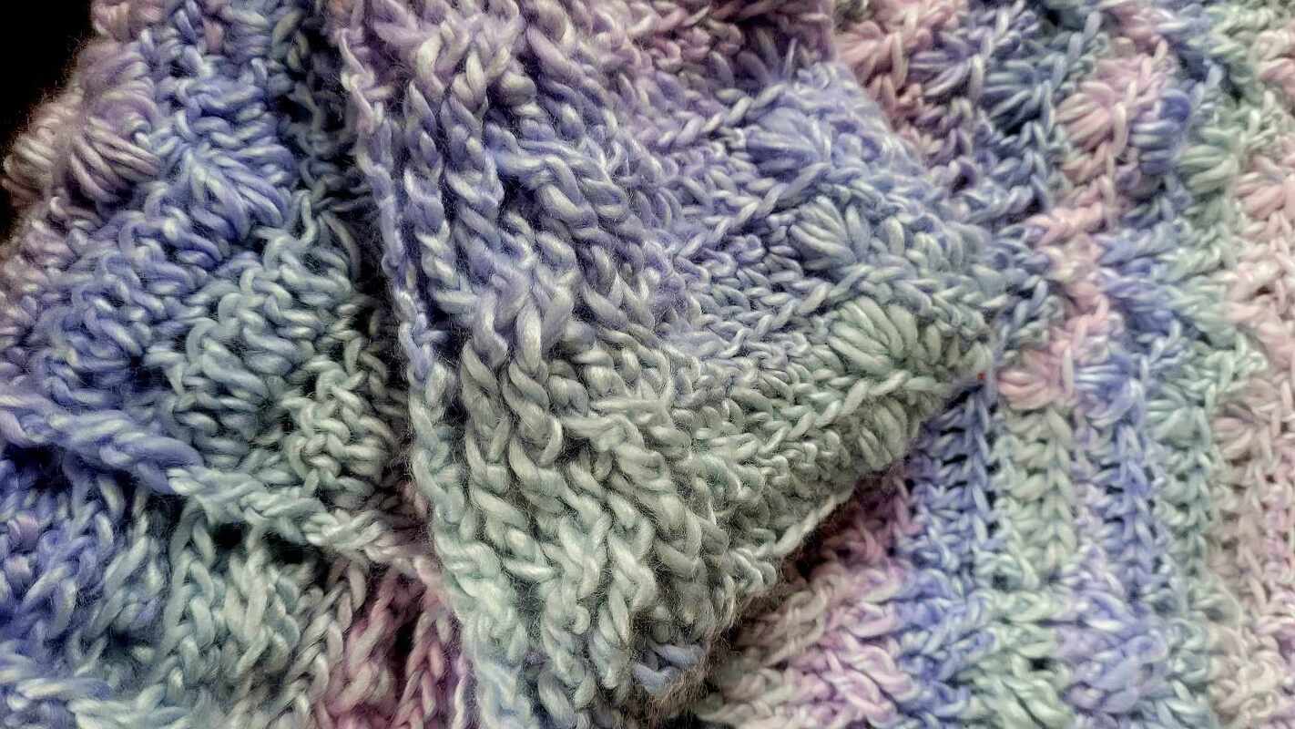 Stitch detail on a variegated triangle crochet shawl for pattern reference