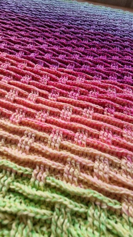 Gehäkelte Babydecke mit Farbverlauf von Grün zu Violett in strukturierter Waffeloptik