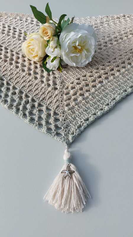 Gehäkeltes Dreieckstuch in Beige-Türkis mit Quaste und Seestern-Anhänger, dekoriert mit weißen Rosen