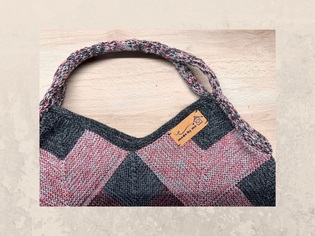 Gestrickte Damen-Schultertasche grau-rosé mit gedrehtem Tragegriff und Lederetikett