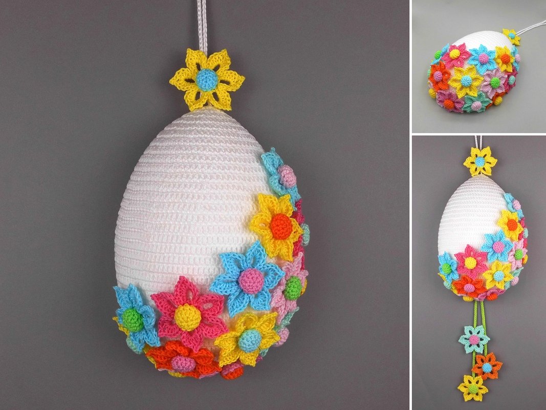 White crocheted egg ornament decorated with multicolored crochet flowers and a hanging loop