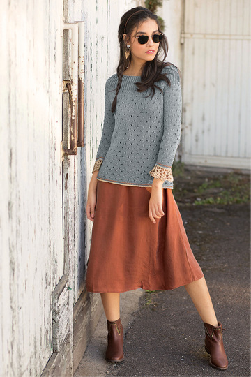 Gestrickter grauer Pulli mit gehäkelten Ärmelbordüren