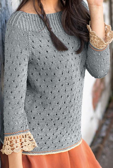 Gestrickter grauer Pulli mit gehäkelten Ärmelbordüren