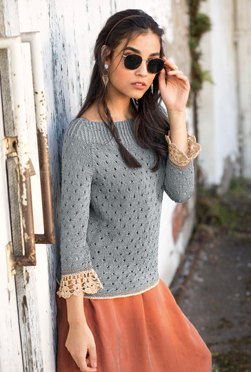 Gestrickter grauer Pulli mit gehäkelten Ärmelbordüren