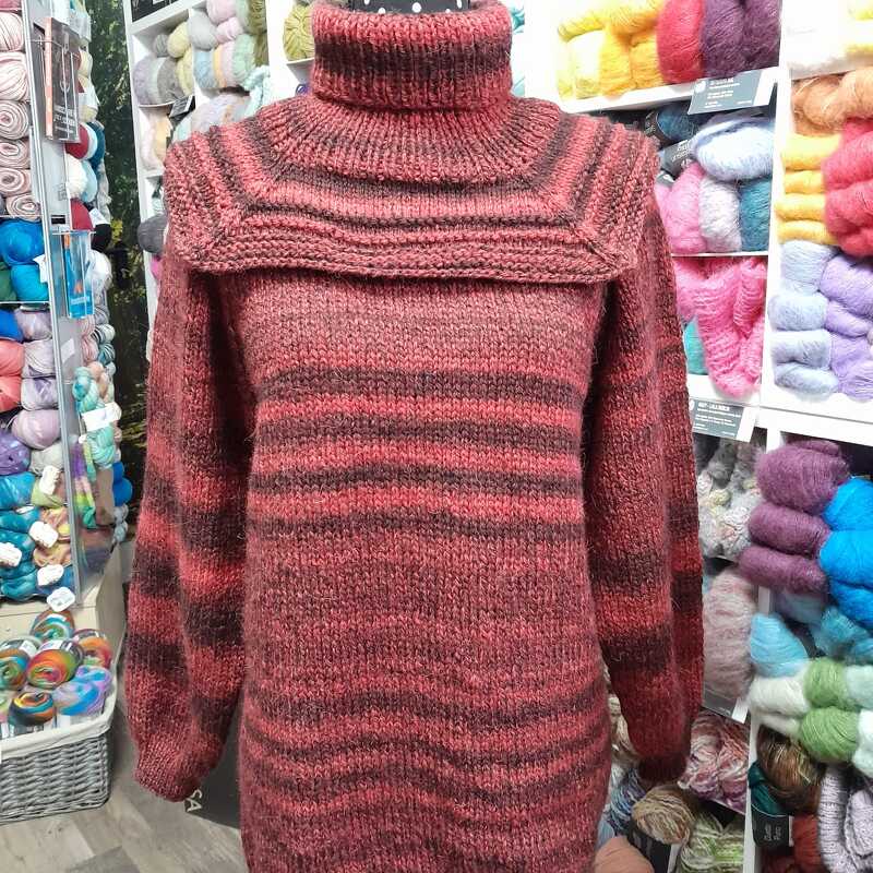 Gestrickter Rollkragenpullover in Rotbraun mit horizontalen Streifen auf einer Schaufensterpuppe.