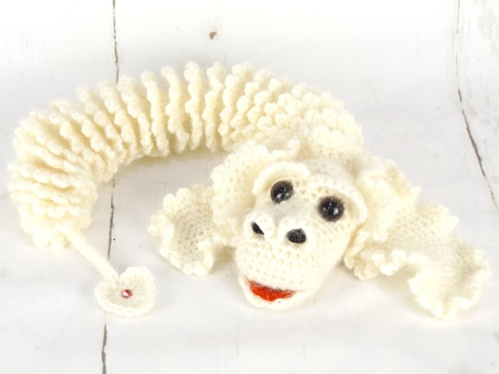 Gehäkelter weißer Glücksdrache Amigurumi mit lockigem Körper und kleinem Herzanhänger