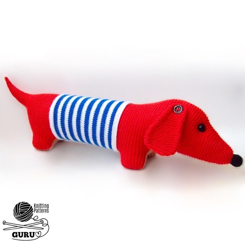 Red knitted dachshund toy with blue-and-white striped midsection, black button eyes and black nose on a white background.