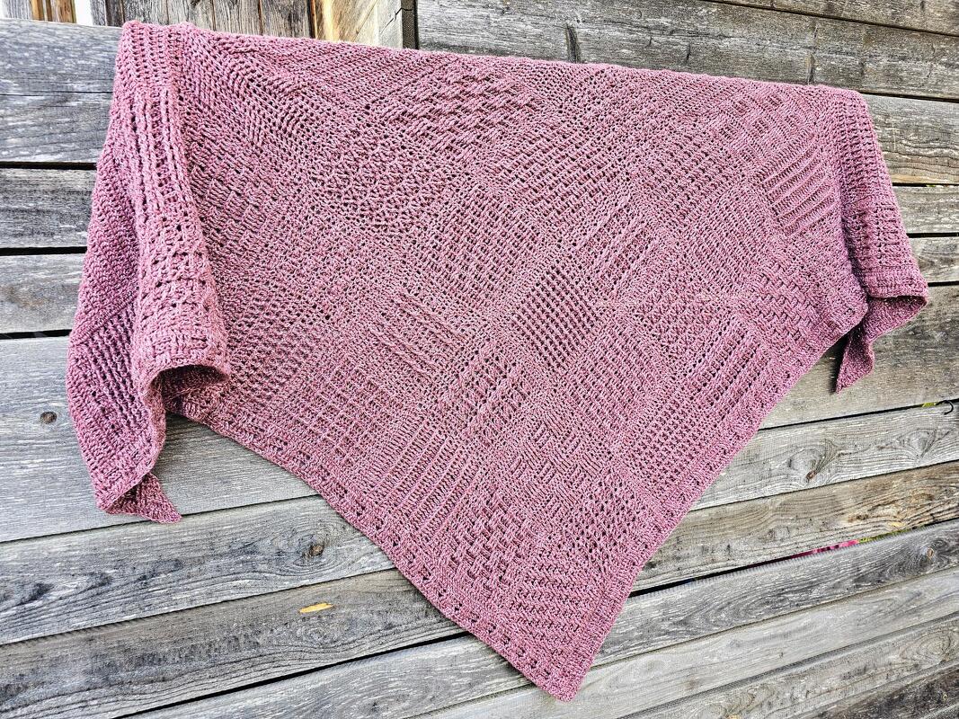 Gehäkeltes mauves Dreieckstuch mit Musterquadraten auf rustikalem Holz