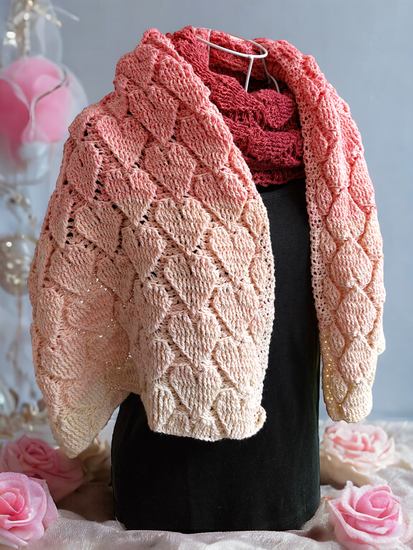 Pink-to-cream gradient crochet loop scarf with heart lace motif on a black dress form