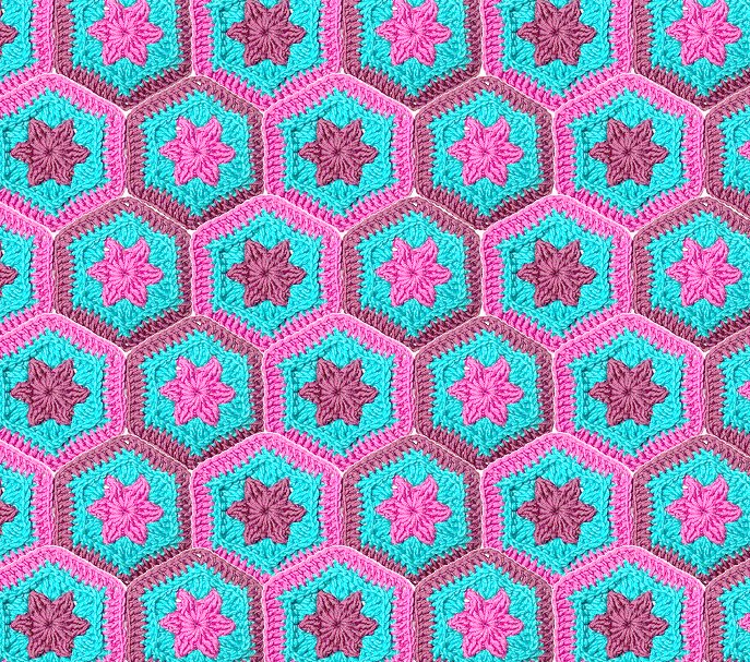 Nahaufnahme gehäkelter Hexagon‑Granny mit sternförmigem Zentrum in Türkis, Pink und Lila
