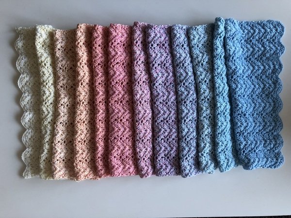 Gehäkelter Schal in Pastell-Ombre (Creme–Rosa–Lila–Blau) mit durchbrochenem Wellenmuster und gewellter Kante