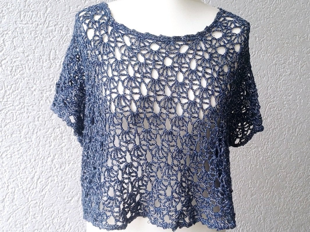 Dunkelblaues gehäkeltes Shirt mit offenem Lochmuster auf weißer Schaufensterpuppe