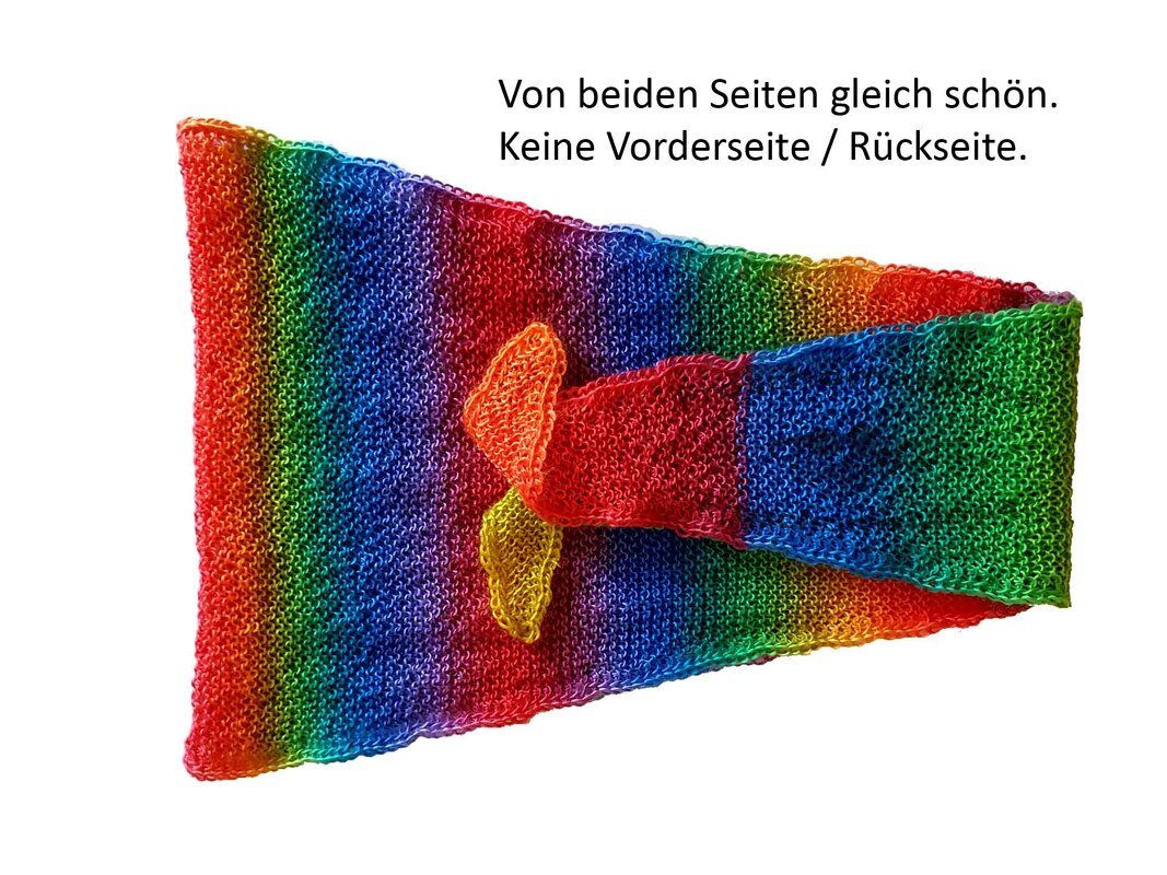 Gestricktes, beidseitig tragbares Dreieckstuch in Regenbogenfarben mit Knoten in der Mitte.