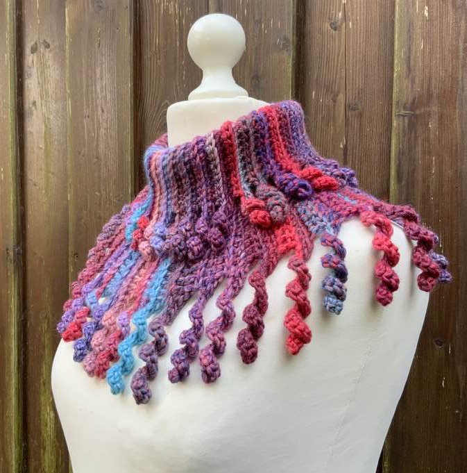 Mehrfarbiger gehäkelter Kragenschal mit geripptem Kragen und spiralförmigen Fransen