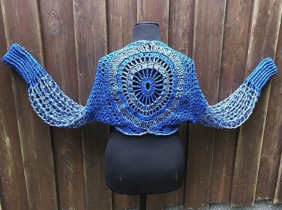 Kurzgeschnittener gehäkelter Bolero in Blautönen, Rückansicht mit rundem Mandala‑Spitzenmotiv