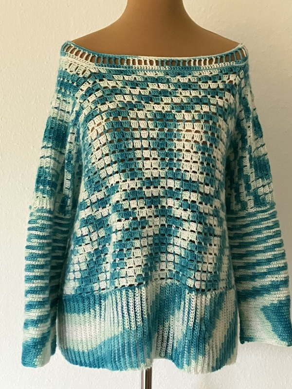 Gehäkelter türkıs-weiß melierter Damenpullover mit offenem Kästchenmuster auf Schneiderpuppe