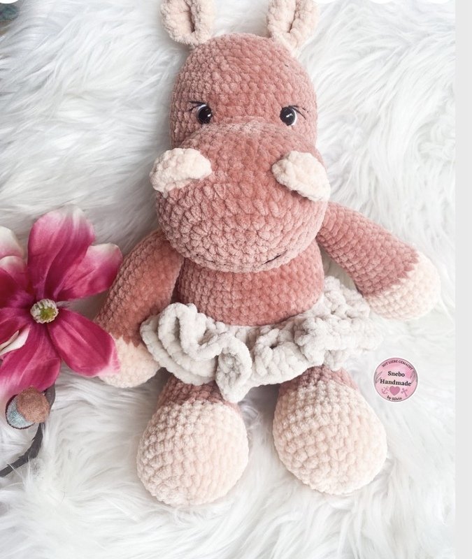 Nahaufnahme eines rosa gehäkelten Amigurumi-Nilpferds mit hellem Rüschenrock